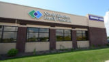 Two patients walk up to the west entrance to Regions Hospital. The west entrance is nestled among park-like landscaping.