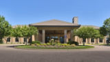A picture of Stillwater Clinic, a modern looking clinic with trees and native landscaping out front.