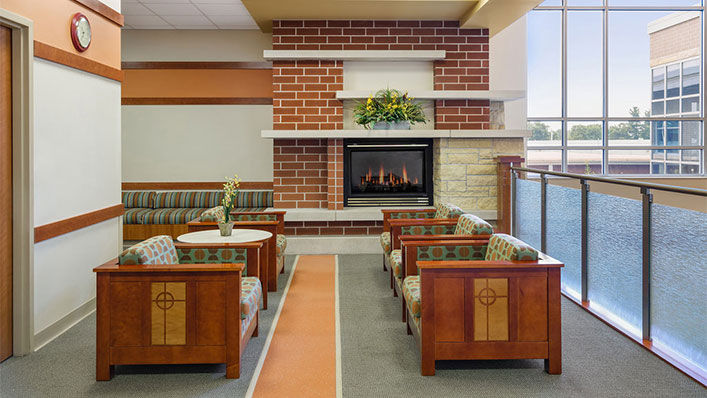 Amery Hospital's cozy waiting room with comfortable seats and a warm fireplace