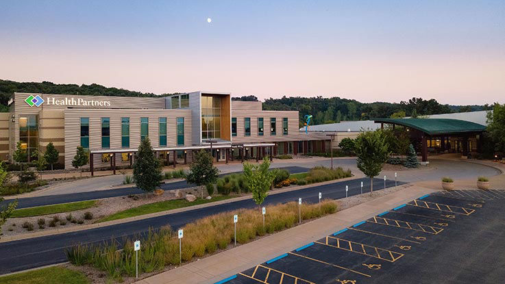 A picture of the front of Hudson Hospital & Clinic and the ample parking lot.