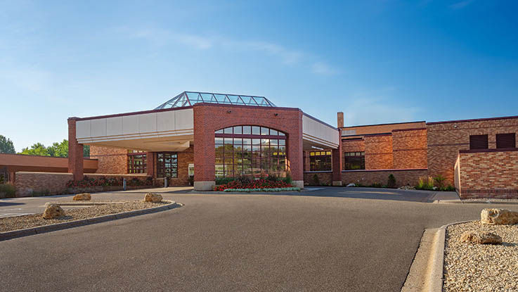 A picture of the entrance of Lakeview Hospital & Clinic. It has a wide driveway and large port cochere for easy access to the main doors.