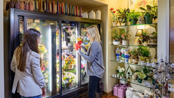 Two women choose a vase of flowers from the gift shop’s wide selection.