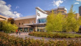 Two patients walk up to the west entrance to Regions Hospital. The west entrance is nestled among park-like landscaping.