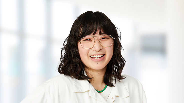 A smiling young woman with glasses and dark hair.