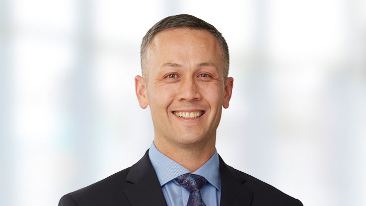 Portrait of John Clark, a smiling white man with short, brown hair.