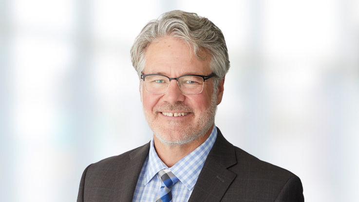 Portrait of Dr. Haake, a smiling white man with grey hair and glasses.