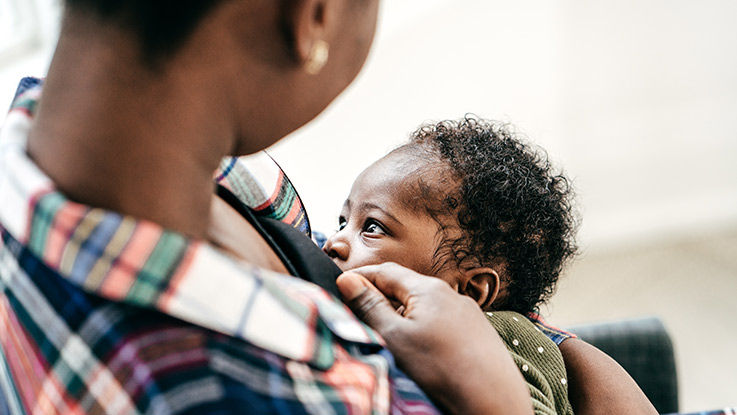 A mother breastfeeds her infant.