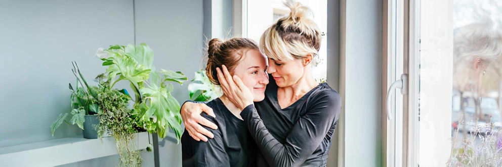 One sister comforts another with a hug and words of encouragement on a cloudy day.