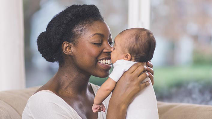 A mom rubs noses with her newborn baby.