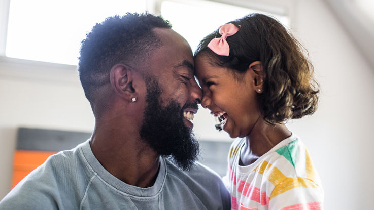 A father and daughter laughing and smiling.