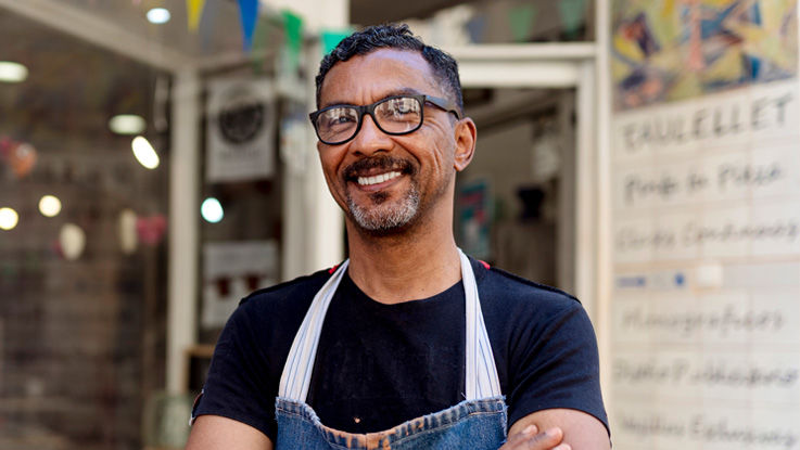 The owner of a bakery smiles into the camera