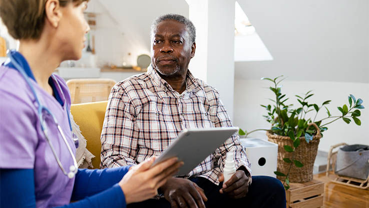 A member of the care team going over the recovery plan with a patient.