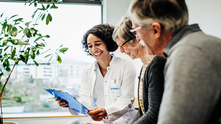 A doctor handing a patient educational documents before a Parkinson’s disease informational class.