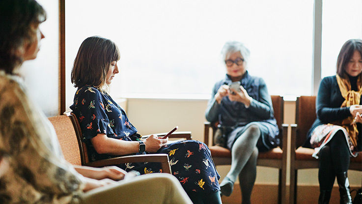 Sitting in a health care clinic’s waiting room, several people quietly scroll through their phones