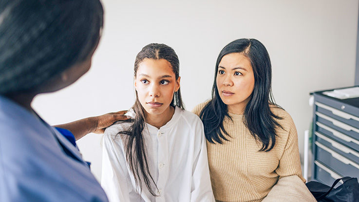 A teen and her mother listen as a nurse shares important nutrition information. 