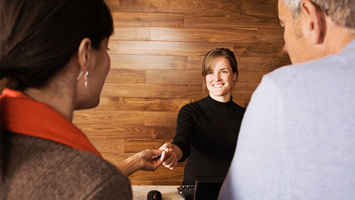 A hotel staff giving their customer a card key