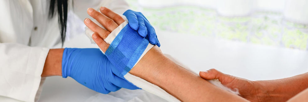 Medium shot of nurse helping to bandage a patient with a hand injury.