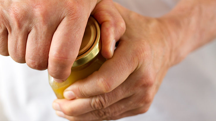 A close-up of hands opening a jar.
