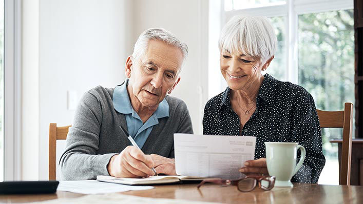 An elderly couple filling out forms