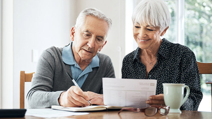 An elderly couple filling out forms.