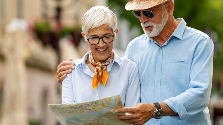 Older couple standing outside and looking at a map.