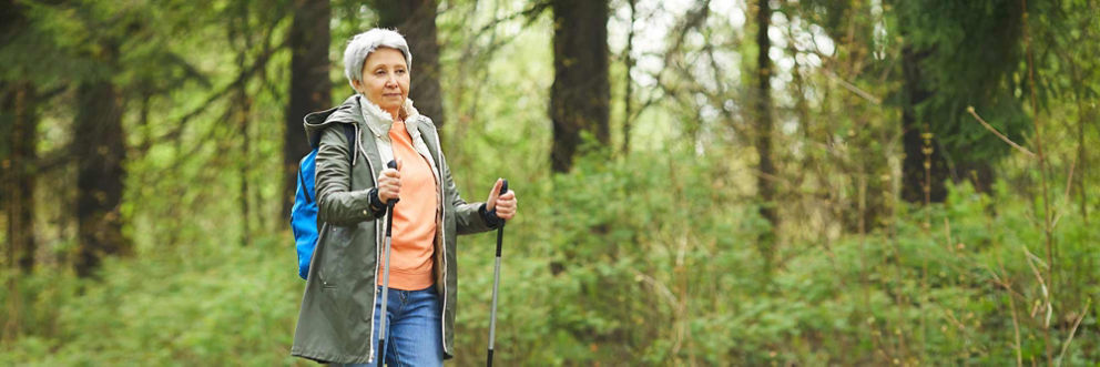 An older woman enjoys a nature hike.
