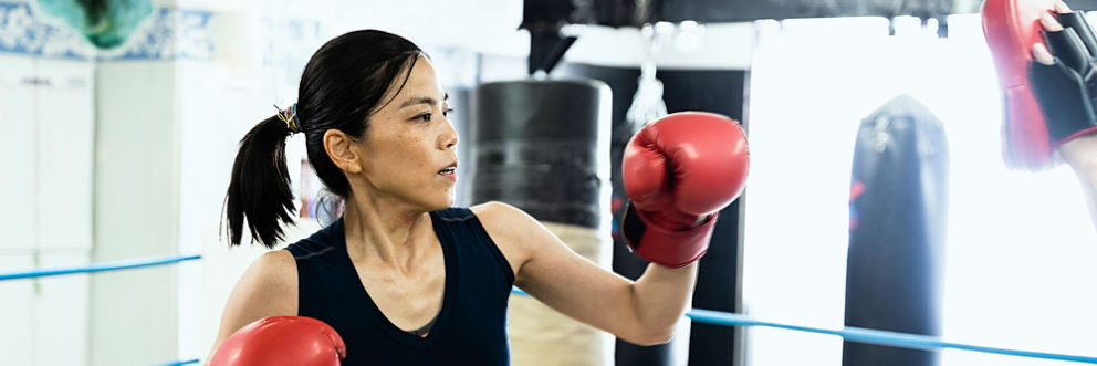 A young woman practices boxing.