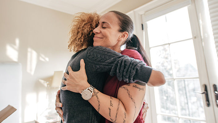 Mother and daughter hugging at home