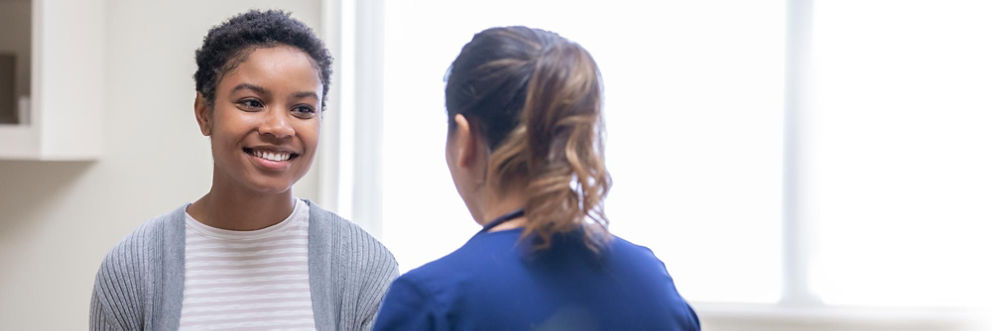 A patient smiles during a conversation with a medical professional.