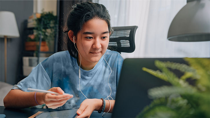 A woman takes notes on a tablet during a video visit for an eating disorder. 
