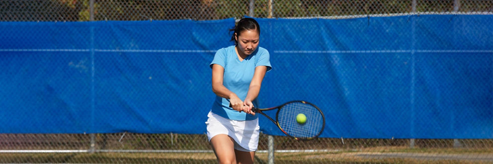 A young woman plays tennis.