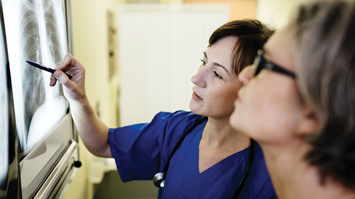 Two female mature doctors discussing a x-ray image in a doctors office