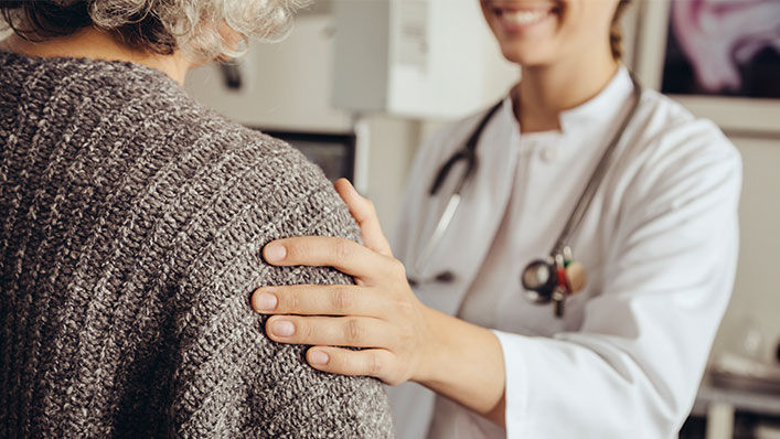 A doctor with her hand on her patient's shoulder 