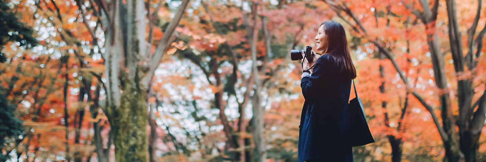 A young woman takes pictures on an autumn day.