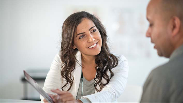 A doctor discusses something during a consultation with her patient.