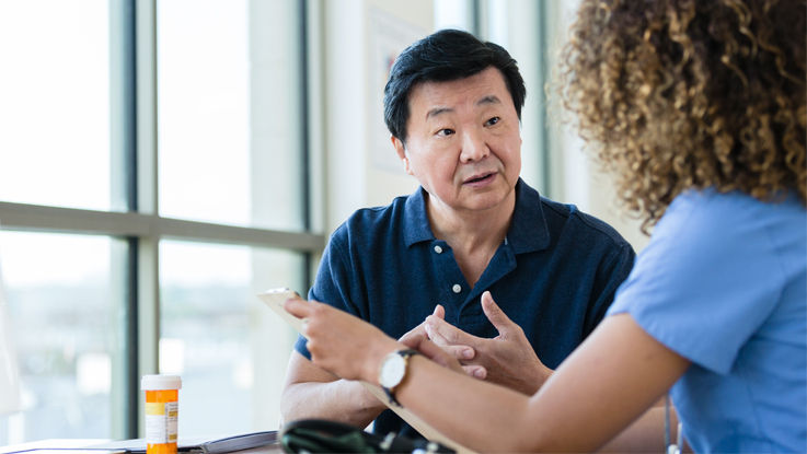 A man speaks with a doctor about his medication.