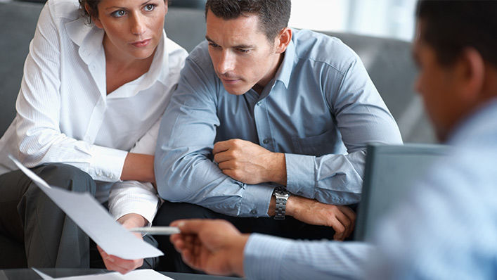 A group of businesspeople review documents and information