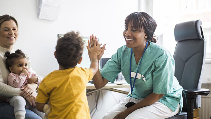 A doctor gives her patient a high five.