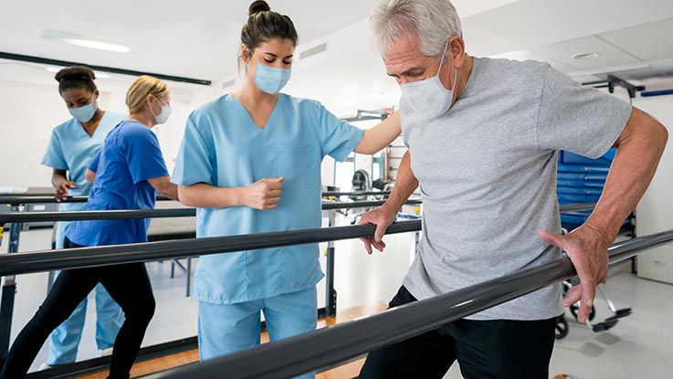 A patient recovers from a stroke with the help of his physical therapist.