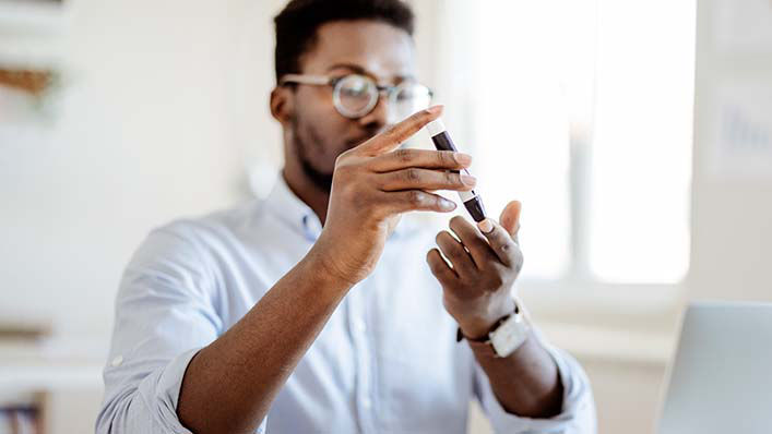 A person with diabetes checks their blood sugar using a blood glucose meter.