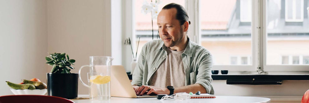 man working from home reviews information and details on his laptop.