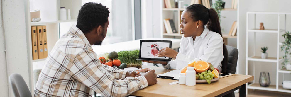 Dietician using food and visuals to discuss nutrition with a patient.
