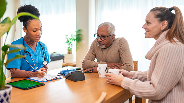 Family members as a hospice nurse explains insurance coverage. 