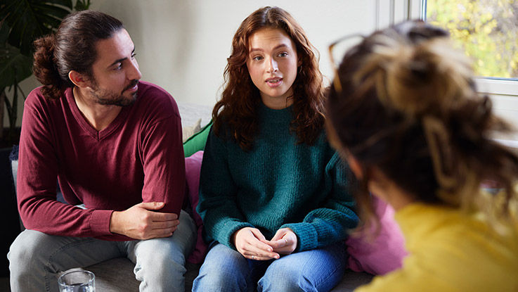 A father listens as his daughter talks during family-based therapy for eating disorders.