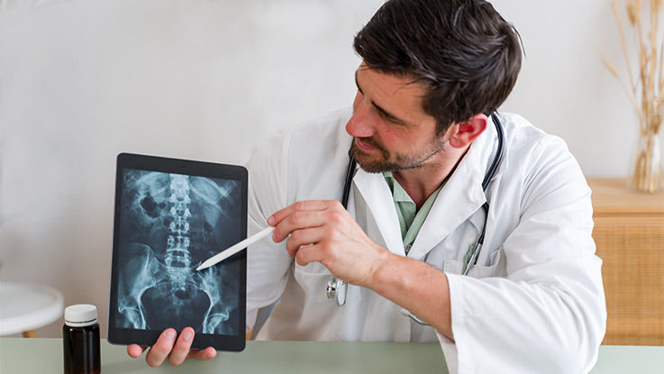 Doctor showing a spine xray to a patient.