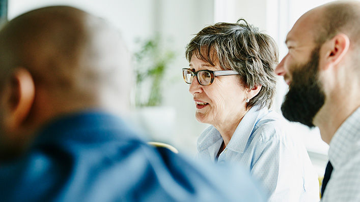 Mature businesswoman leading team meeting in office conference room