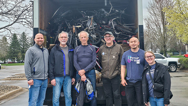 HealthPartners team members stand in front of a moving truck full of bikes.
