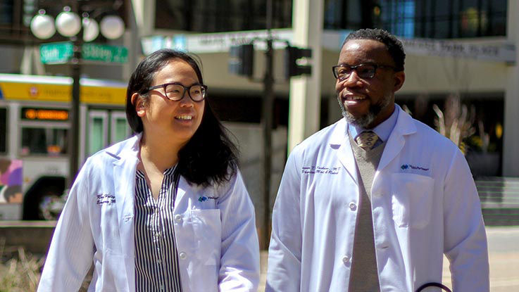 Two of the doctors who work at HealthPartners chat while they enjoy a walk through the city.